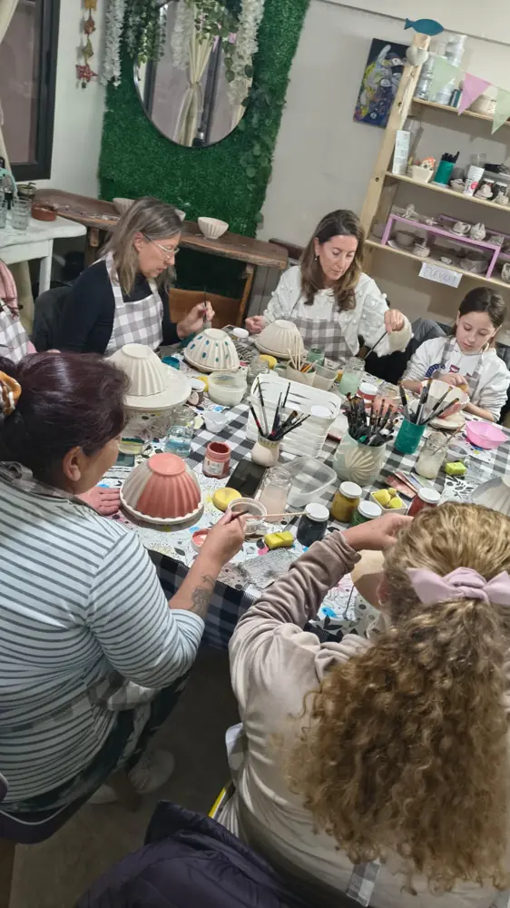 Personas compartiendo una mesa de trabajo en el taller de cerámica